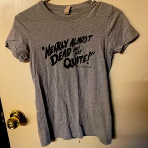 Gray t-shirt with stylized “NEARLY ALMOST DEAD BUT NOT QUITE” text.